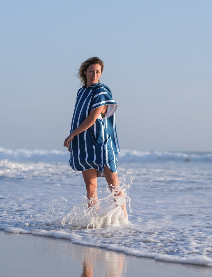 femme dans l'eau avec un poncho bleu