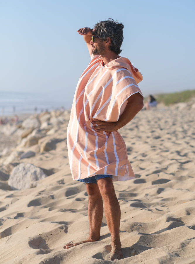 homme avec un poncho en microfibre à rayure qui regarde l'horizon