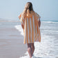 fille qui marche sur la plage en poncho microfibre à rayures orange