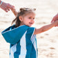petite fille qui tient la main de ses parents en marchant sur la plage habillée avec un poncho en microfibre bleu beachee