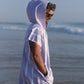un homme sur la plage avec un poncho en microfibre de couleur lilas 