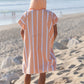 personne de dos avec un poncho à capuche de couleur pêche