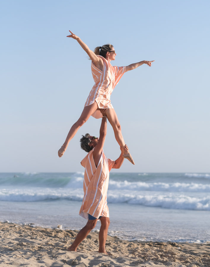 couple faisant une figure acrobatique en poncho orange