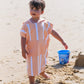 enfant qui fait un château de sable qui porte poncho de plage en microfibre