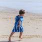 enfant qui court sur la plage avec un poncho en microfibre bleu
