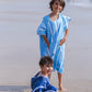 deux enfants sur la plage avec des ponchos