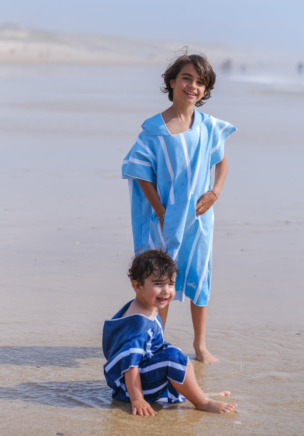 deux enfants sur la plage avec des ponchos