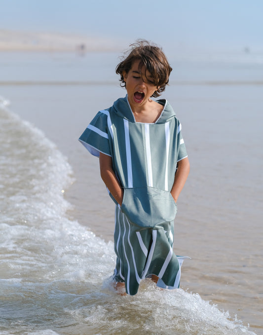 enfant en poncho en microfibre kaki dans l'eau 